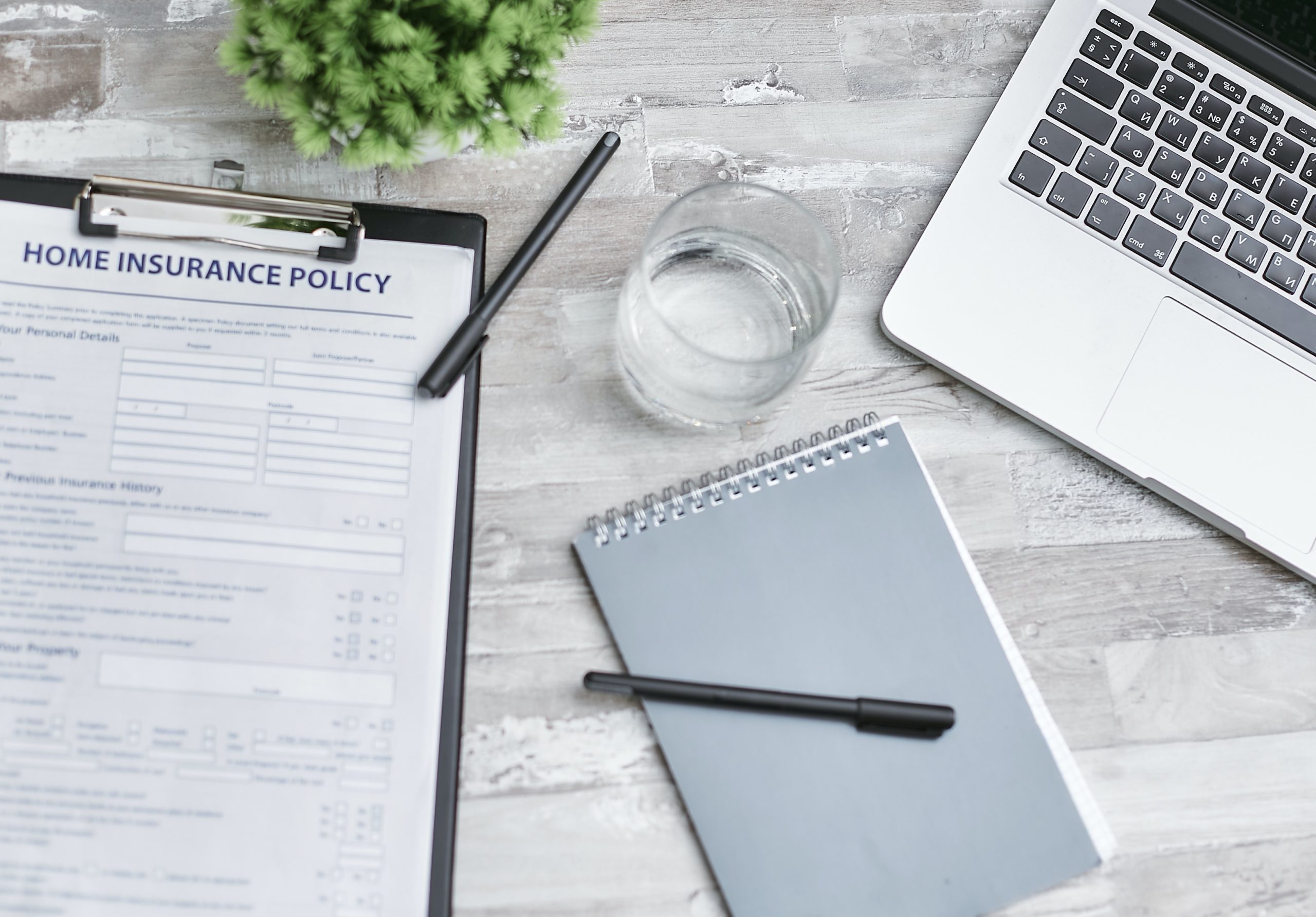 desk with laptop and home insurance policy