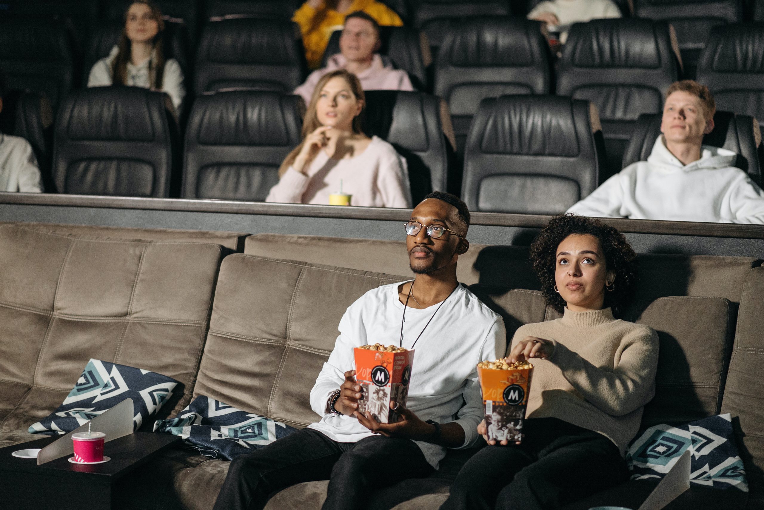 couple watching movie at theater eating popcorn