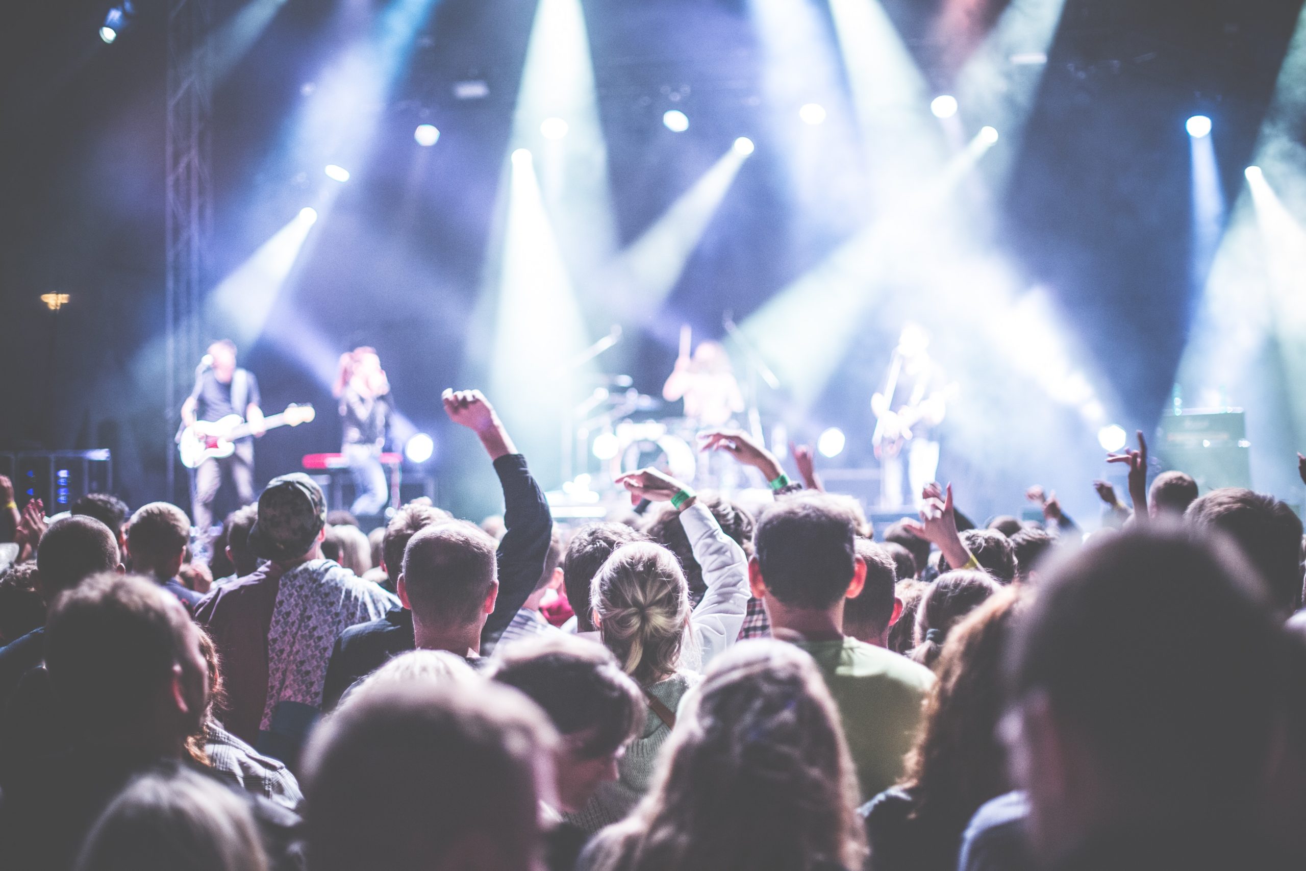 pexels-picjumbocom-196652 hands in air at concert spotlights on crowd
