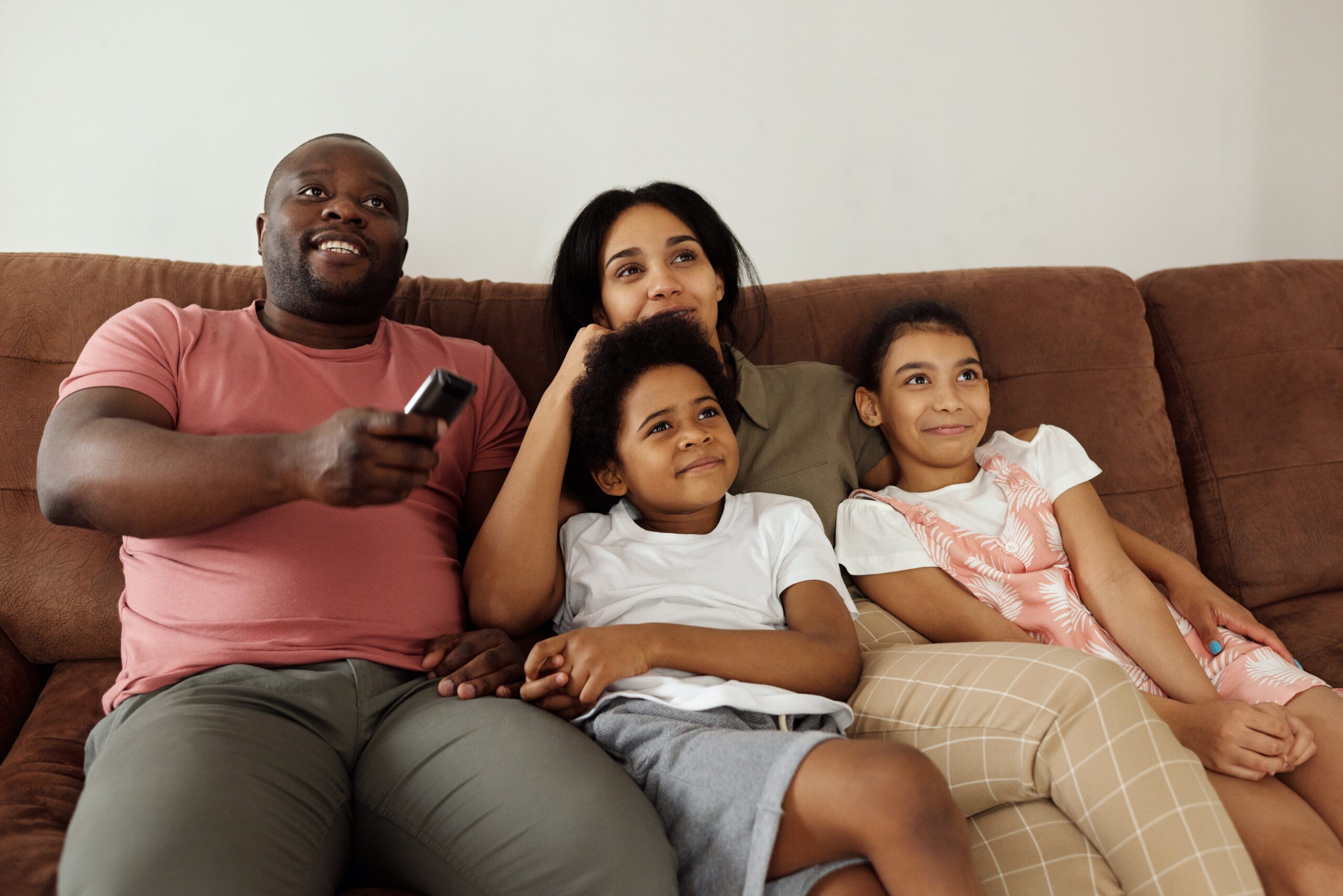 family sitting on couch watching TV owasso home rental blog streaming vs cable