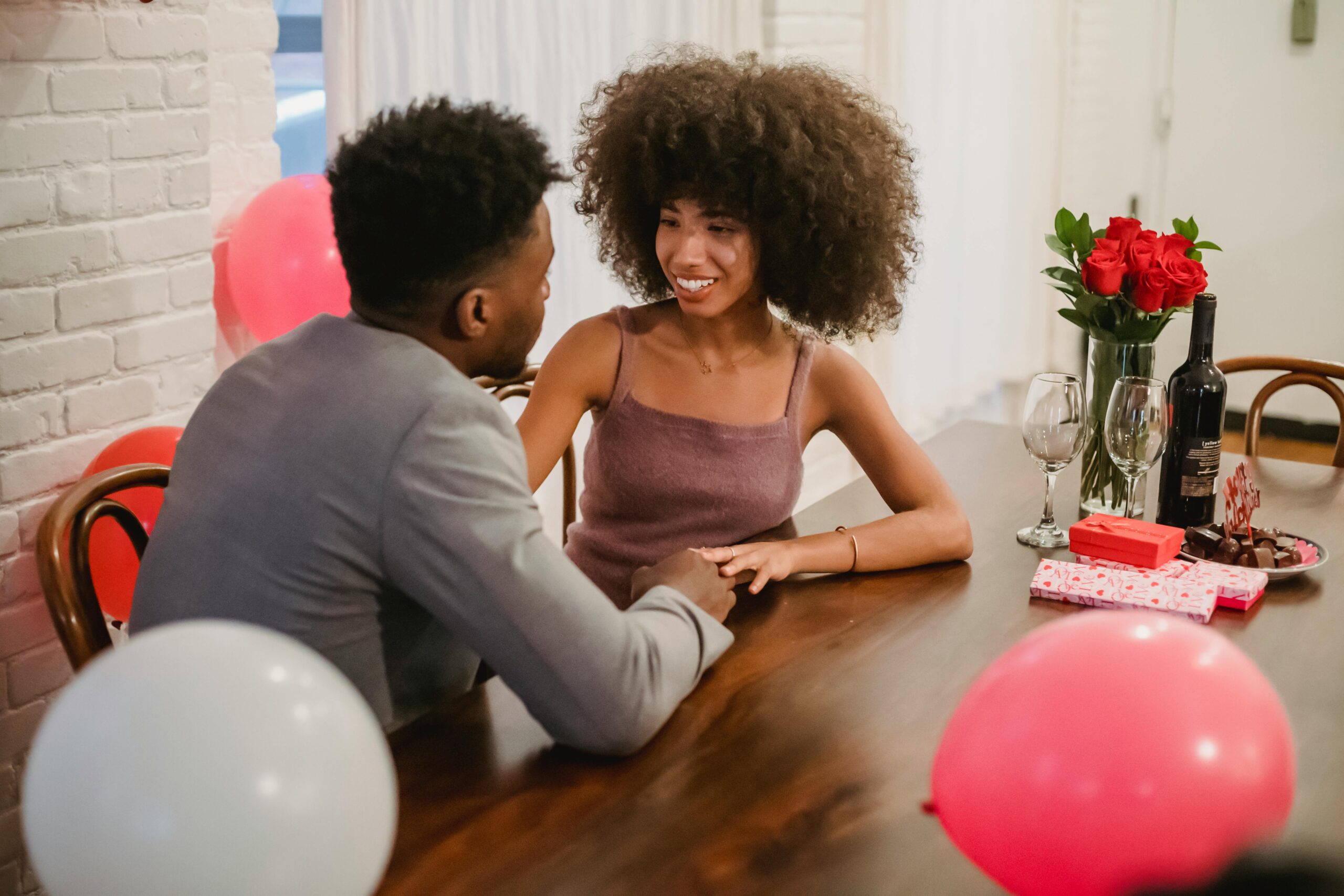 pexels-andres-ayrton-6578956 couple smiling at table at home date night legacy living blog ideas